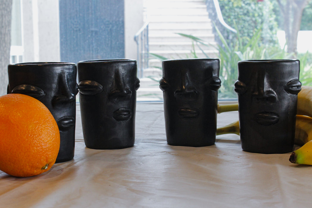 Vasos de barro negro con diseño de cara